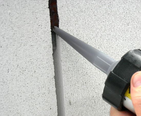 Герметизация швов в каменной стене с помощью акрилового герметика - фото